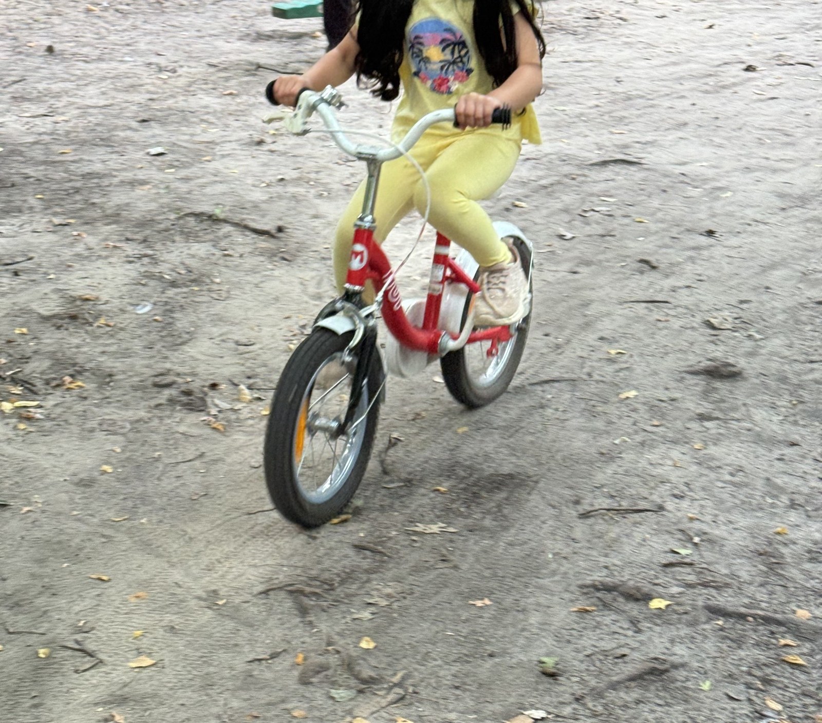 Kind fährt mit dem Fahrrad durch den Kita-Garten