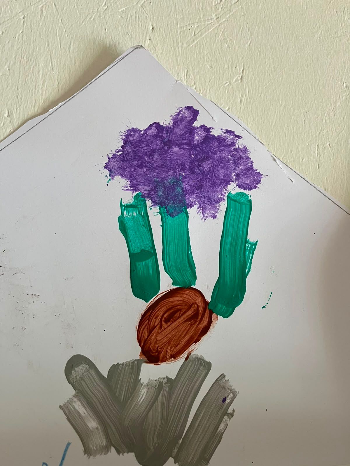 Gemalte Blume aus Handabdrücken in Lila und Grün